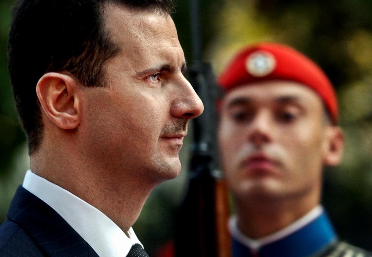 Syrian President Bashar Assad reviews the presidential guard during a welcoming ceremony in Athens on Dec. 15, 2003. (AP Photo/Petros Giannakouris)