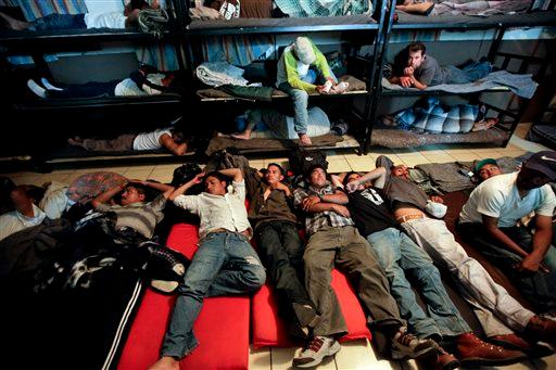 In this April 28, 2010, file photo, men look for a place to sleep in a crowded shelter for migrants deported from the United States, in the border city of Nogales, Mexico. (AP Photo/Gregory Bull)