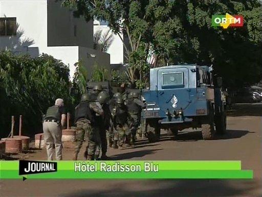 In this TV image taken from Mali TV ORTM, Security forces approach the Radisson Blu Hotel hotel in Bamako, Mali, Friday Nov. 20, 2015. Men shouting "God is great" and armed with guns and throwing grenades stormed into the Radisson Blu Hotel in Mali's capital Friday morning. (Mali TV ORTM, AP)