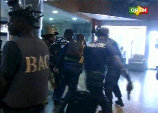 In this TV image taken from Mali TV ORTM, security forces help hostages to safety, inside the Radisson Blu Hotel in Bamako, Mali, Friday Nov. 20, 2015. Men shouting "God is great" and armed with guns and throwing grenades stormed into the Radisson Blu Hotel in Mali's capital Friday morning. (Mali TV ORTM, AP)