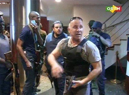 In this TV image taken from Mali TV ORTM, a security officer gives instructions to other security forces inside the Radisson Blu Hotel in Bamako, Mali, Friday Nov. 20, 2015. Men shouting "God is great" and armed with guns and throwing grenades stormed into the Radisson Blu Hotel in Mali's capital Friday morning. (Mali TV ORTM, AP)