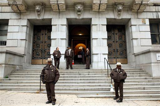 Members of the Baltimore City Sheriff's Office stand outside Clarence M. Mitchell Jr. Courthouse, Monday, Nov. 30, 2015, in Baltimore, after the arrival of William Porter, one of six Baltimore city police officers charged in connection to the death of Freddie Gray. (AP Photo/Patrick Semansky)