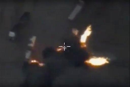 In this photo made from the footage taken from Russian Defense Ministry official web site on Friday, Dec. 4, 2015 an aerial image of what they purport shows an airstrike on an automobile column transporting oil products in Aleppo province, Syria. (AP Photo/ Russian Defense Ministry Press Service)