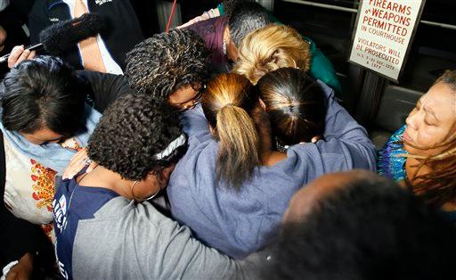 Supporters of the victims of former Oklahoma City police officer Daniel Holtzclaw pray after the verdicts were read for the charges against him at the Oklahoma County Courthouse in Oklahoma City, Thursday, Dec. 10, 2015. Holtzclaw was convicted of raping and sexually victimizing eight women on his police beat in a minority, low-income neighborhood. (Nate Billings/The Oklahoman via AP)