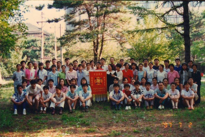 Che Pingping (6th from the left, 2nd row) and Wang Huilian (2nd from the left, 3nd row) stand for a group photo at the exercise site at Northeast Normal University on July 2, 1997. (Courtesy of Wang Huilian)