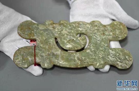 A jade pendant, which dates back to the Hongshan culture (about 4700 to 2900 B.C.), is recovered when 175 people tomb raiders were arrested in May 2015. (Xinhua News Agency)