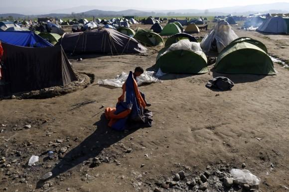 A boy plays with an abandoned tent in the makeshift refugee camp at the northern Greek border point of Idomeni, Greece, Thursday, March 31, 2016. (AP Photo/Darko Vojinovic)