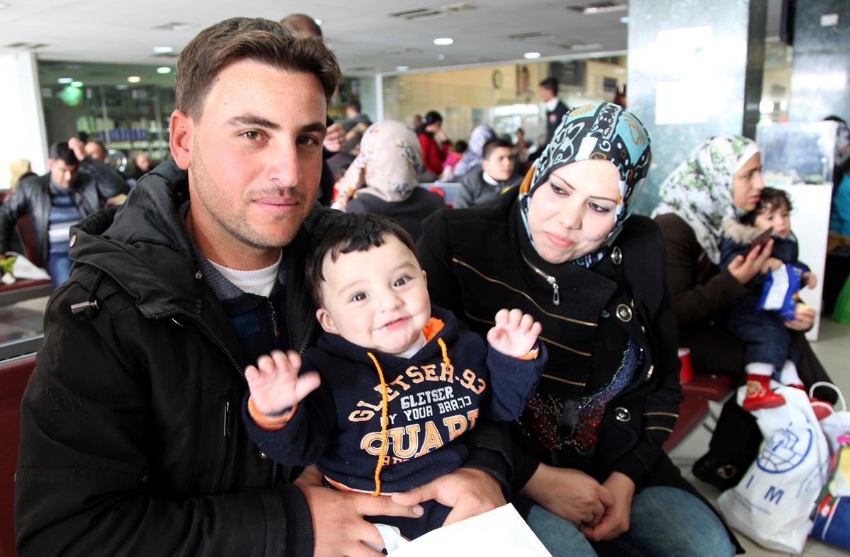 Radi poses for a photo with his son and wife while waiting in an airport in Amman, Jordan, to board a plane to Canada where they will be resettled, on Dec. 20, 2015. (AP Photo/Sam McNeil)