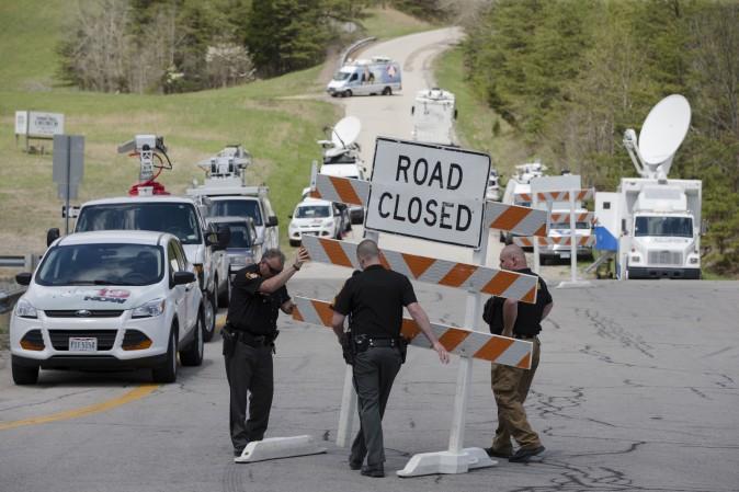 Authorities set up road blocks at the intersection of Union Hill Road and Route 32 at the perimeter of a crime scene, Friday, April 22, 2016, in Pike County, Ohio. (AP Photo/John Minchillo)