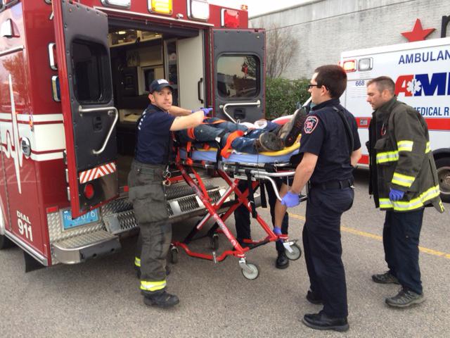 The suspect in attacks at Silver City Galleria mall is transported on a gurney into an ambulance by medical personnel in Taunton, Mass. on May 10, 2016. Multiple people have been stabbed in separate deadly attacks at the mall and a home in Massachusetts. Authorities say an off-duty law enforcement officer shot and killed the suspect. (Charles Winokoor/The Daily Gazette via AP)