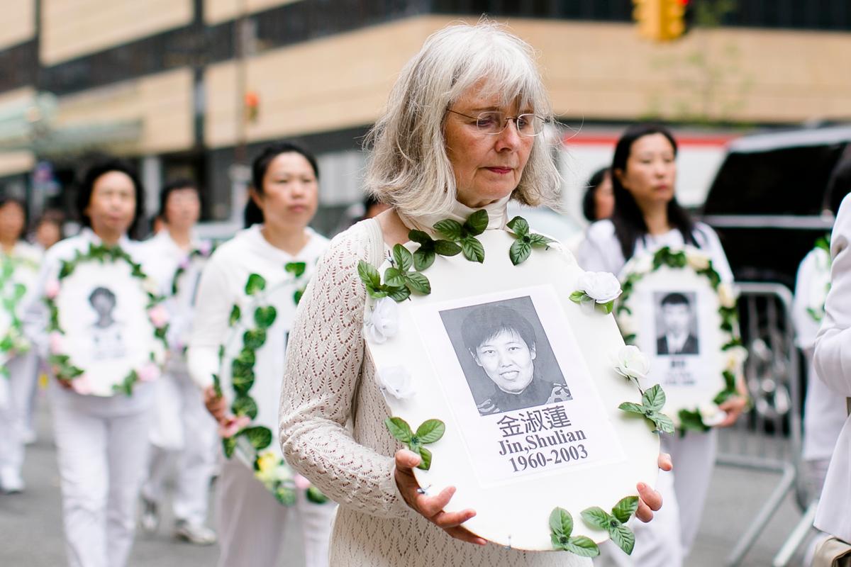 Falun Gong practitioners hold portraits of those killed in the persecution in China during the World Falun Dafa Day parade along 42nd Street in New York, on May 13, 2016. (Samira Bouaou/Epoch Times)