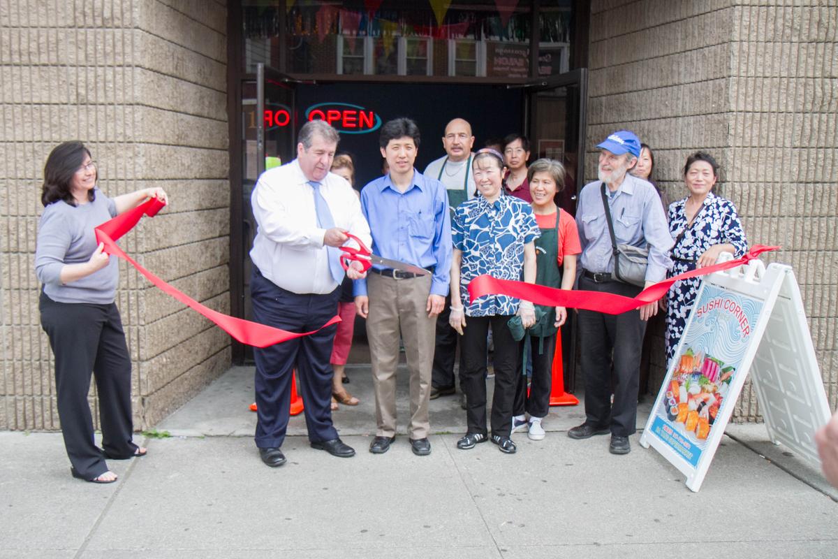 Middletown Mayor Joseph DeStefano cuts a ribbon at the city's ribbon cutting ceremony for Da Tang Supermarket in Middletown on May 27, 2016. Standing next to him are city officials and Da Tang Supermarket employees. (Holly Kellum/Epoch Times)
