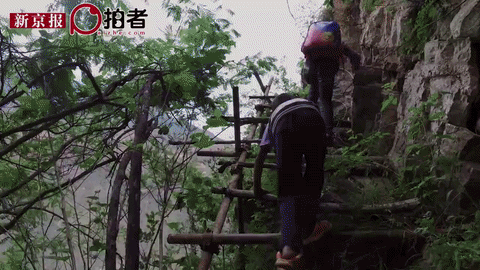 Children climbing on the ladder of the mountain. (via Beijing News)