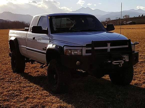 Tanner George Flores drives a white 1999 Dodge 2500 diesel pickup truck, pictured above, with the Colorado license plate: 121XGO. (Larimer County Sheriff's Office)