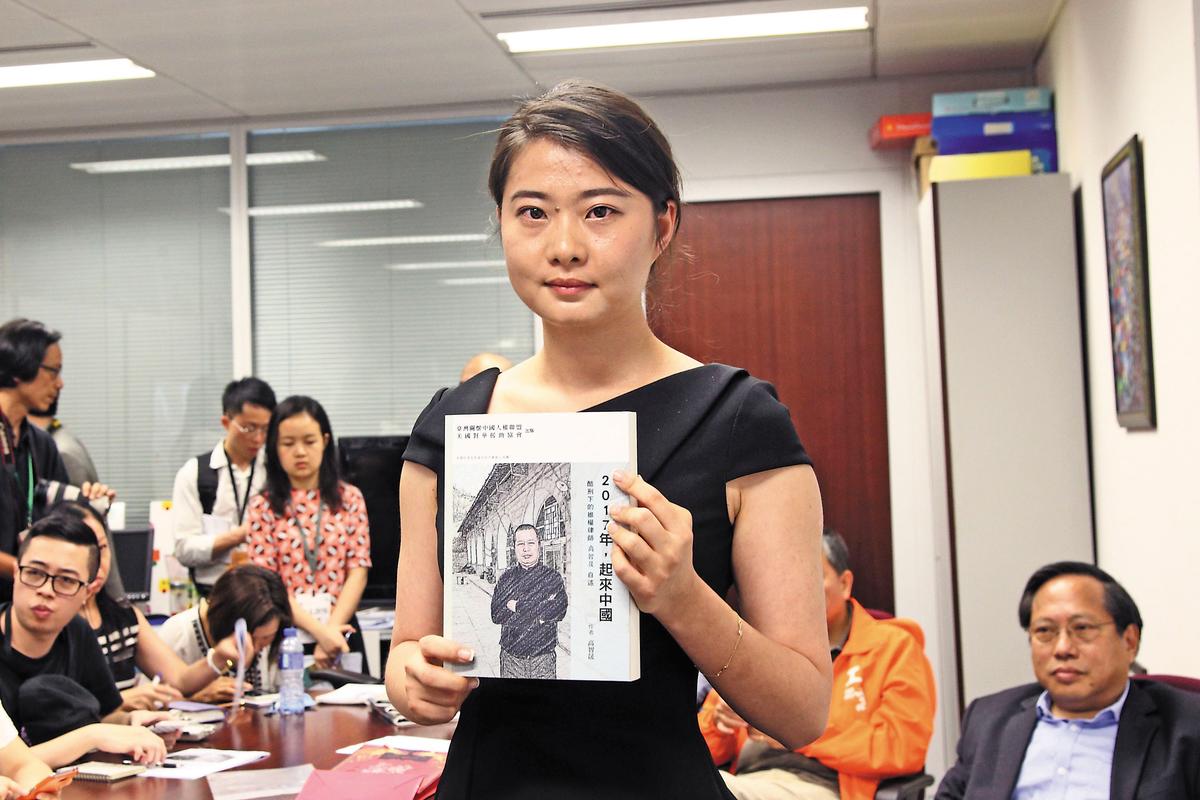 Grace Geng, Gao Zisheng's daughter, holds a copy of Gao's new book at the book launch ceremony, in Hong Kong on June 16, 2016. (Stone Poon/Epoch Times)
