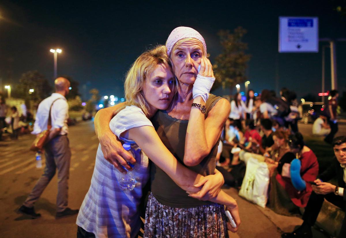 Family members embrace after being evacuated following a blast at the Istanbul's Ataturk airport which was claimed by ISIS on June 29. The attack killed dozens and wounded many others. (AP Photo/Emrah Gurel)