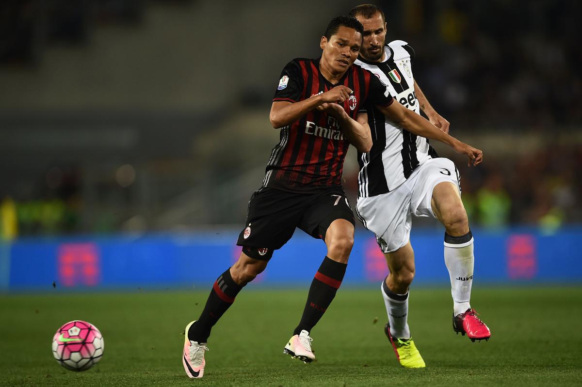 Milan forward Carlos Bacca (L) fights for the ball with Juventus' Giorgio Chiellini during the Italian Tim Cup final in Rome on May 21. A group of Chinese investors paid $500 million to acquire A.C. Milan this month. (Filippo Monteforte/AFP/Getty Images)