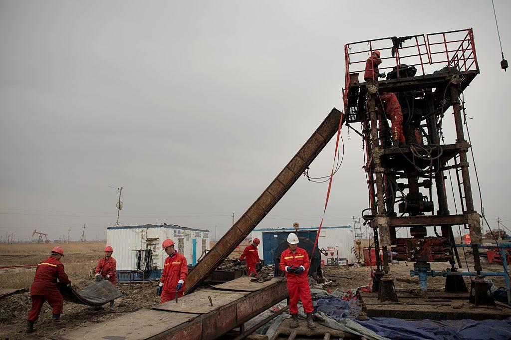 Workers construct an oil rig in Daqing, Heilongjiang province on May 2, 2016. (Nocolas Asfour/AFP/Getty Images)