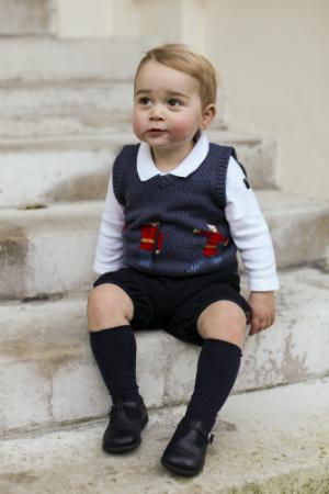 In this handout image of three released on Dec. 13, 2014, by Kensington Palace, Prince George sits for his official Christmas picture in a courtyard at Kensington Palace in late November of 2014 in London. (The Duke and Duchess of Cambridge/PA Wire via Getty Images)