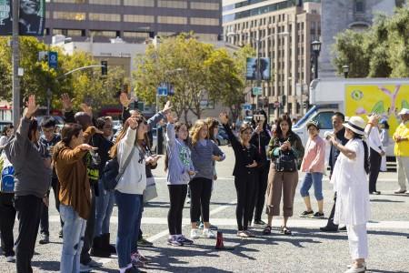 Passersby learn the Falun Gong exercises before the anti-persecution parade in San Francisco on July 16. (Epoch Times)