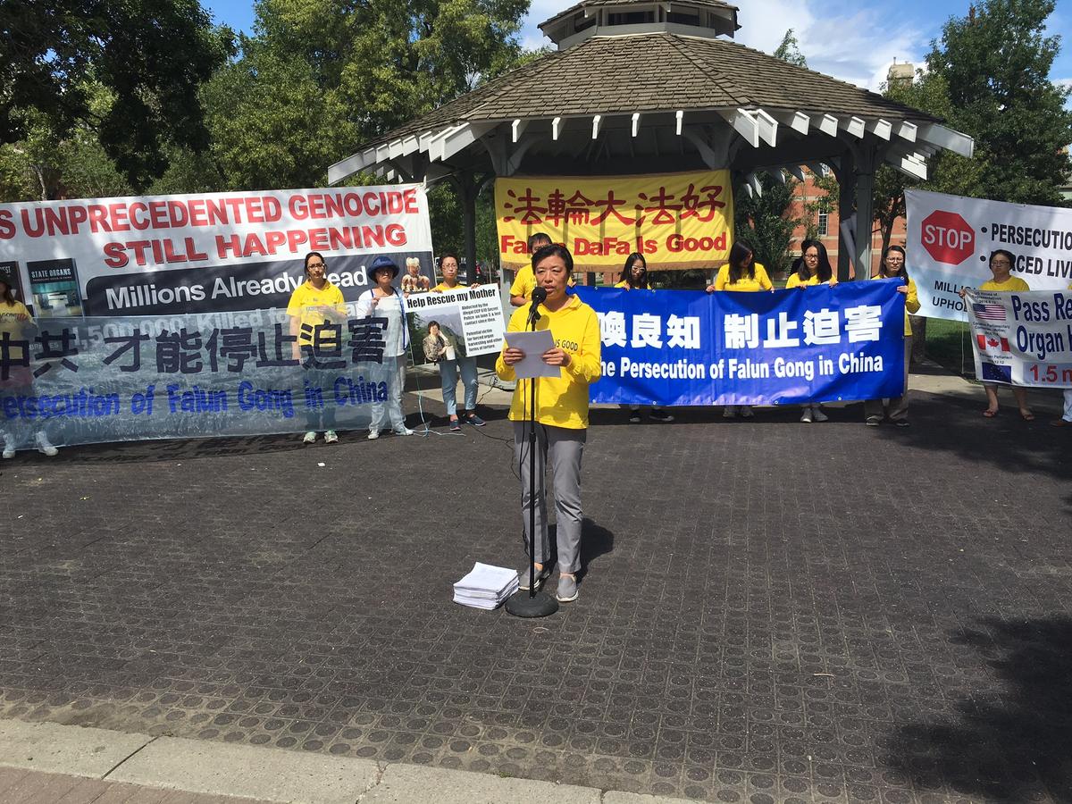 Minnan Liu speaks at a rally in Edmonton on July 23, 2016 to commemorate the 17th anniversary of the persecution of Falun Dafa in China. Liu presented the over 9,000 petitions signed by Edmontonians since last year to bring to justice the former Chinese leader Jiang Zemin who started the persecution on July 20, 1999. Behind her Hongyan Lu holds a sign asking for support to release her mother, Huixia Chen, who is currently detained in China for practicing Falun Dafa. (Omid Ghoreishi/Epoch Times)