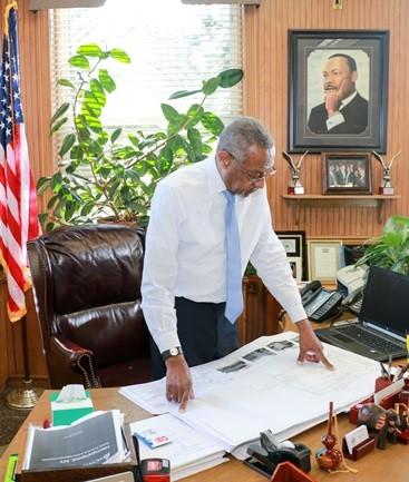 Mayor Hall reviews blueprints for projects included in the village's downtown revitalization project in his office at City Hall in the village of Hempstead, N.Y. (Courtesy Office of Mayor Wayne J. Hall)