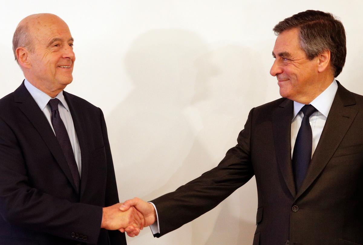 Alain Juppe (L) shakes hands with Francois Fillon after the conservative presidential primary in Paris, on Nov. 27, 2016. (AP Photo/Christophe Ena)