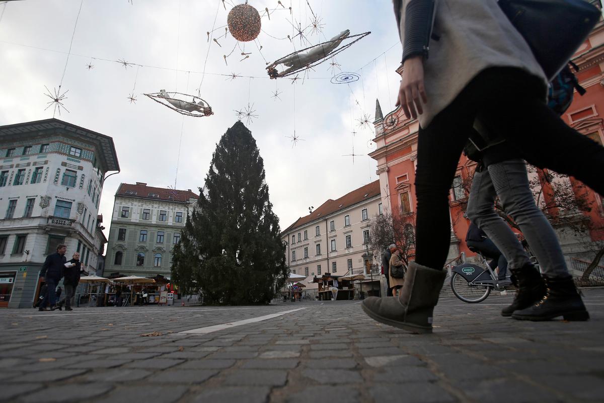 Pedestrians walk in front of the Christmas tree named Melania, in downtown Ljubljana, Slovenia on Nov. 28, 2016. (AP Photo/Darko Vojinovic)