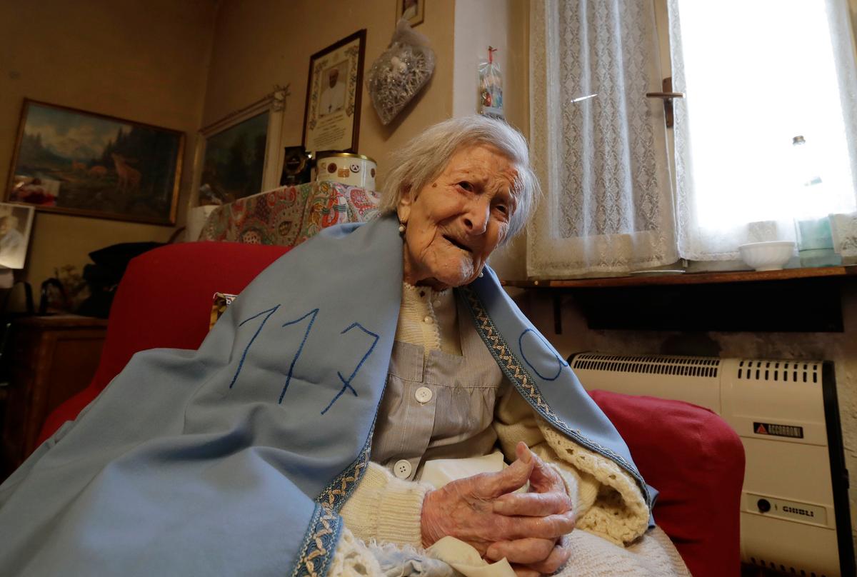 Emma Morano wears a sheet reading 117, in the day of her birthday in her home in Verbania, Italy on Nov. 29, 2016. (AP Photo/Antonio Calanni)