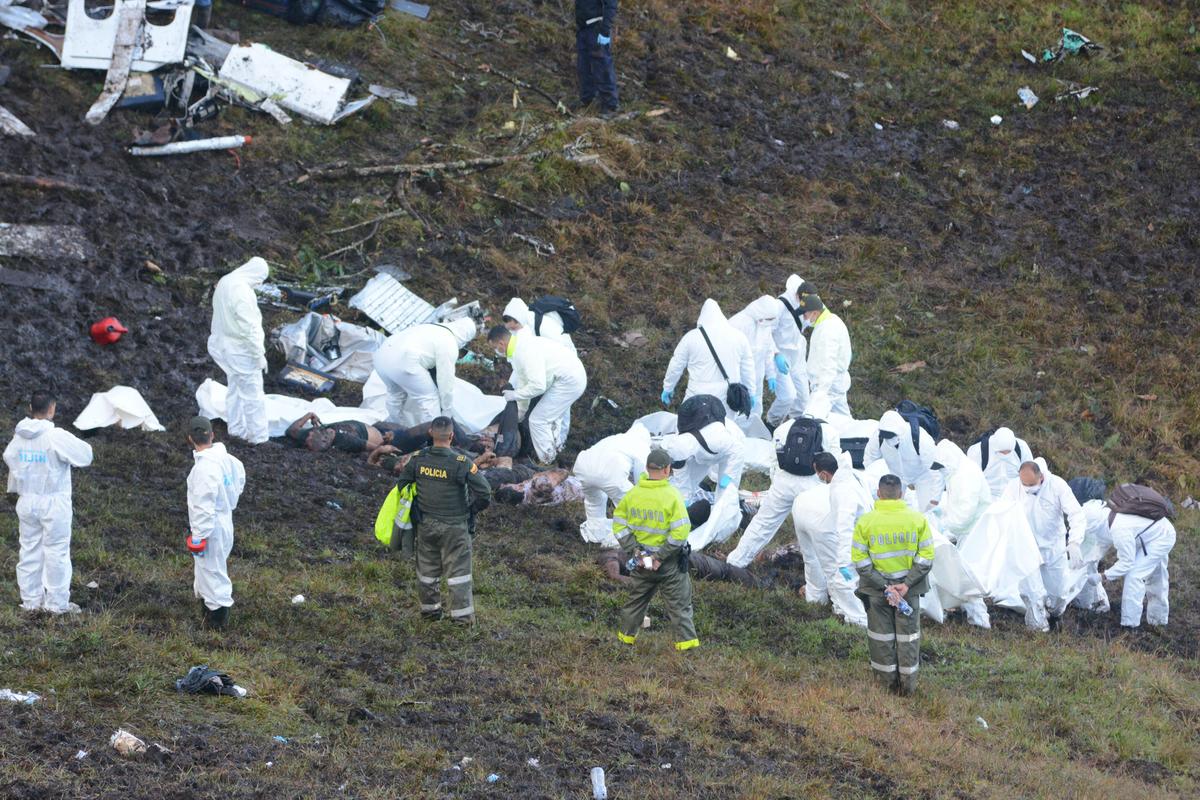 Rescue workers search at the wreckage site of a chartered airplane that crashed outside Medellin, Colombia, on Nov. 29, 2016. (AP Photo/Luis Benavides)