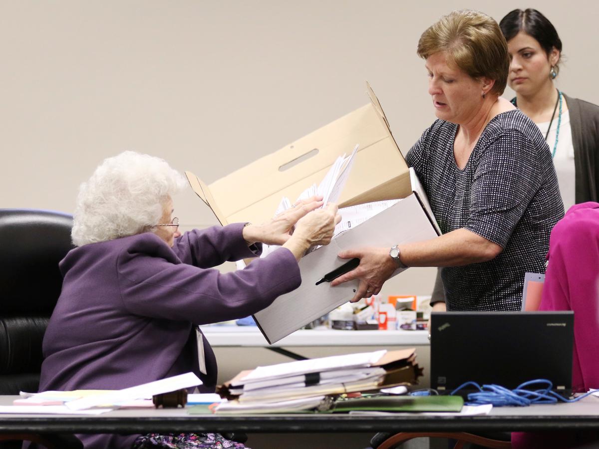 County Clerk Brenda Jaszewski holds a box of absentee ballots from the town of Erin, Wis., as Board of Canvass member Marilyn Merten reaches to take a ballot out during a statewide presidential election recount in West Bend, Wis., on Dec. 1, 2016. (John Ehlke/West Bend Daily News via AP)