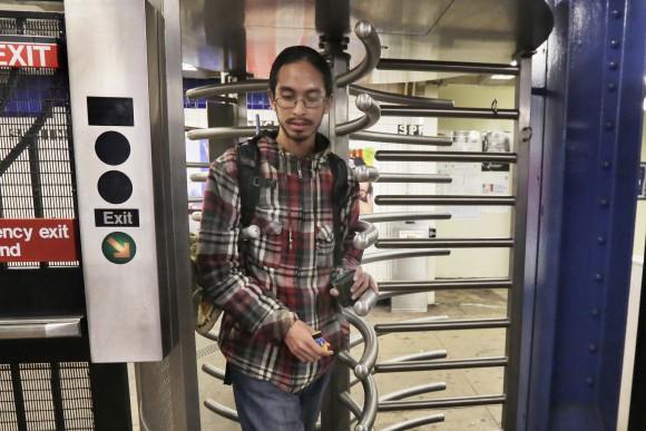 Samuel Santaella, 23, from the Queens borough of New York, uses his MetroCard enters the subway, in New York, on Nov. 30, 2016. (AP Photo/Richard Drew)