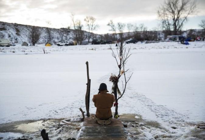 Army veteran Nick Biernacki, of Indiana, prays at the Cannonball River. (AP Photo/David Goldman)