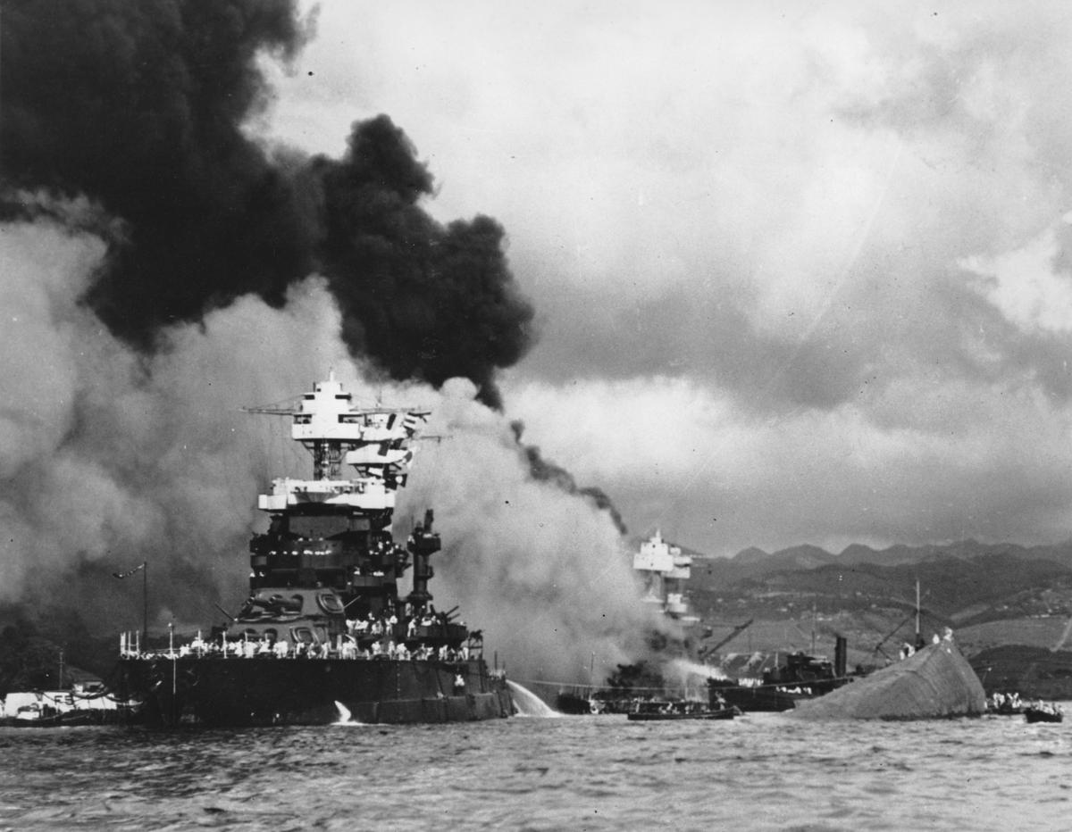 Part of the hull of the capsized USS Oklahoma is seen at right as the battleship USS West Virginia (C) begins to sink after suffering heavy damage, while the USS Maryland (L) is still afloat in Pearl Harbor, Oahu, Hawaii, in this file photo. (AP Photo/U.S. Navy)