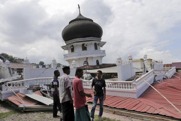 Men inspect a collapsed mosque after an earthquake in Pidie Jaya, Aceh province, Indonesia, on Dec. 7, 2016. (AP Photo/Heri Juanda)