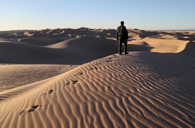 A U.S. Border Patrol agent stands atop a dune along the U.S.-Mexico border at the Imperial Sand Dunes on near Felicity, Calif., on Nov. 18, 2016. (John Moore/Getty Images)