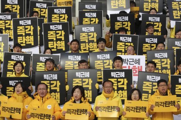 Lawmakers and members of opposition Justice Party hold signs during a rally demanding the impeachment of South Korean President Park Geun-hye at the National Assembly in Seoul, South Korea, on Dec. 8, 2016. (AP Photo/Ahn Young-joon)