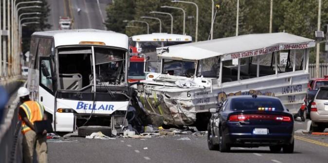 In this Sept. 24, 2015, file photo, a "Ride the Ducks" amphibious tour bus, right, and a charter bus remain at the scene of a fatal collision on the Aurora Bridge in Seattle.  (AP Photo/Elaine Thompson, File)