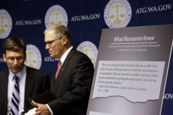 Washington Attorney General Bob Ferguson, left, introduces Gov. Jay Inslee at a news conference where Ferguson announced a lawsuit against agrochemical giant Monsanto over pollution from PCBs, Thursday, Dec. 8, 2016, in Seattle.