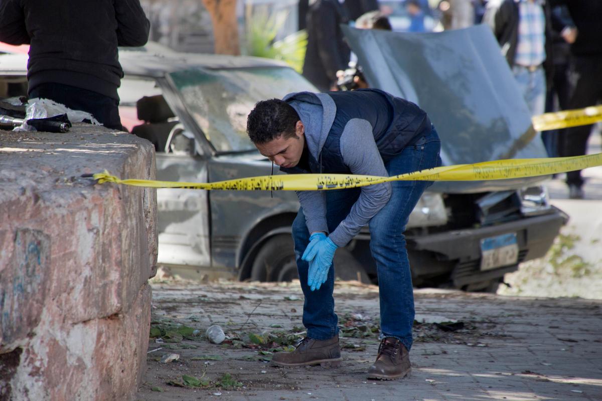 An Egyptian explosives expert looks for evidence at the site of a bomb explosion in Cairo, Egypt, on Dec. 9, 2016. (AP Photo/Amr Nabil)