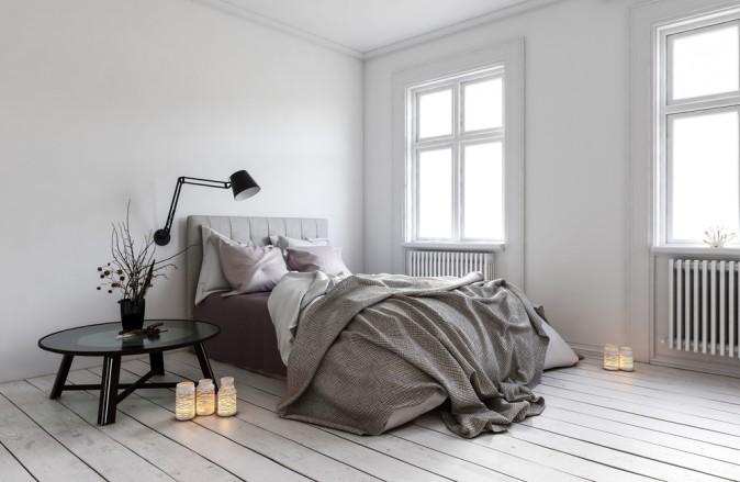 Large windows and minimal furniture is a simple, classic style. The messy bed is also a characteristic of Scandinavian design. (PlusONE/Shutterstock)