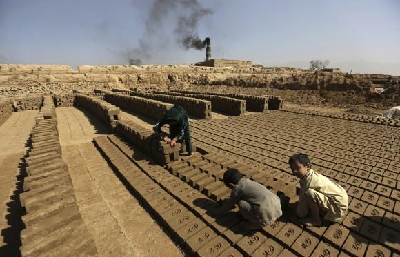 In this file photo, Afghan children help their father's work at a local brick factory on the outskirts of Kabul, Afghanistan. (AP Photo/Rahmat Gul, File)