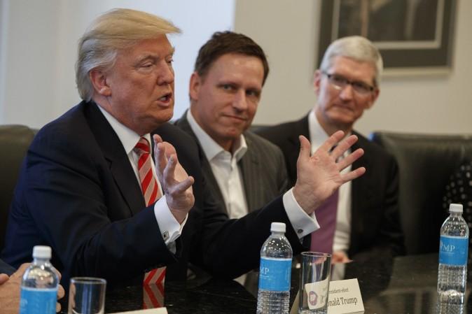 Apple CEO Tim Cook (R) and PayPal founder Peter Thiel (C) listen as President-elect Donald Trump speaks during a meeting with technology industry leaders at Trump Tower in New York on Dec. 14, 2016. (AP Photo/Evan Vucci)