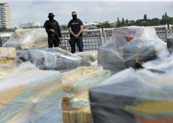 Coast Guardsmen stand over pallets containing more than 26 tons of cocaine worth at least $715 million on the flight deck of of 418-foot Coast Guard Cutter Hamilton, Thursday, Dec. 15, 2016, in Fort Lauderdale, Fla. The cocaine was brought ashore Thursday following multiple recent seizures by the U.S. Coast Guard and the Royal Canadian Navy in the eastern Pacific. (AP Photo/Lynne Sladky)