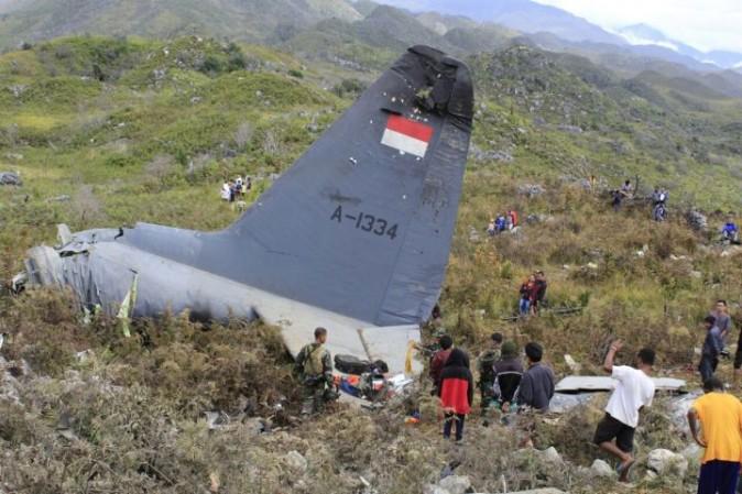 Rescuers collect personal belongings of the victims of an Indonesian Air Force plane that crashed in the mountainous area in Wamena, Papua province, Indonesia Sunday, Dec. 18, 2016. The Hercules C-130 transport plane crashed in bad weather in the easternmost province, killing all people on board. (AP Photo/Gerry Kossay)
