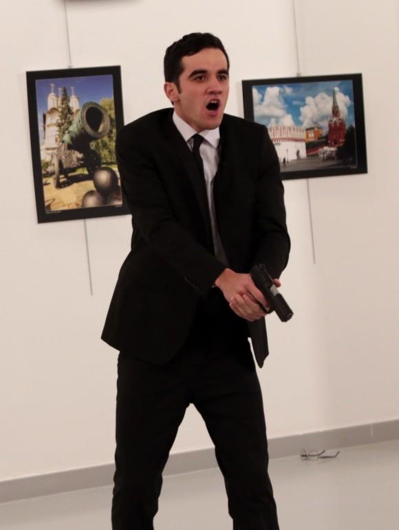 A man identified as Mevlut Mert Altintas holds up a gun after shooting Andrei Karlov, the Russian Ambassador to Turkey, at a photo gallery in Ankara, on Dec. 19, 2016.