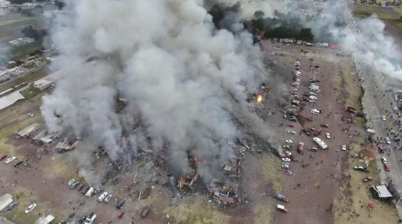 This image made from video provided by APTN, shows a view from a drone of smoke billowing from the San Pablito Market, where an explosion ripped through a fireworks market in Tultepec, Mexico on Dec. 20, 2016. Sirens wailed and a heavy scent of gunpowder lingered in the air after the afternoon blast at the market, where most of the fireworks stalls were completely leveled. According to the Mexico state prosecutor there are dozens dead. (Pro Tultepec via APTN)