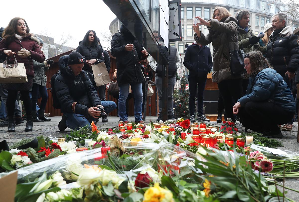 People lay flowers near where a day before a lorry plowed through a Christmas market in Berlin, Germany, on Dec. 20. (Sean Gallup/Getty Images)