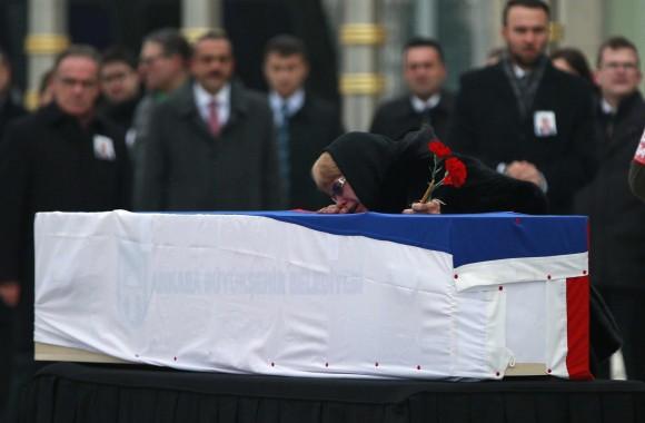 The wife of Russian Ambassador to Turkey Andrei Karlov who was assassinated Monday, cries over her husband's coffin, draped in the Russian flag, during a ceremony at the airport in Ankara, Turkey, on Dec, 20, 2016. (AP Photo/ Emrah Gurel)