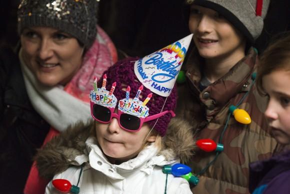 Stella Luken, 5 of Dublin, Ohio, wears a birthday hat and a pair of birthday sun glasses as she waits in line to see Colo, the nation's oldest living gorilla, during Colo's 60th birthday party at the Columbus Zoo and Aquarium, on Dec. 22, 2016. (AP Photo/Ty Wright)